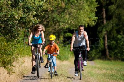 Family with child on their bikes on a summer day in sport outfit, FOCUS ON SON ONLY