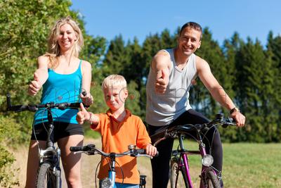 Family with child on their bikes on a summer day in sport outfit, they are exercising