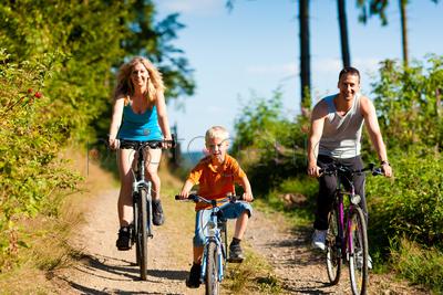 Family with child on their bikes on a summer day in sport outfit, they are exercising